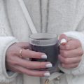 整洁的办公桌角，一位校对人员拿着红笔在打印出的英文材料上圈画标注，旁边摆着两台设备用于交叉比对译文，背景是书架